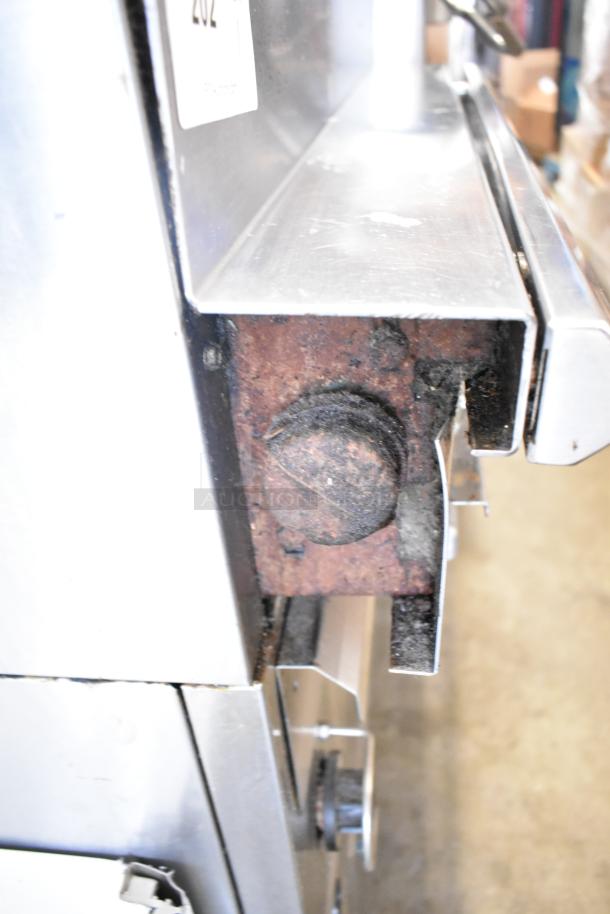 US Range Commercial Gas Charbroiler Grill with Oven, stainless steel, visible rust and wear, side view of unit, tag displayed.