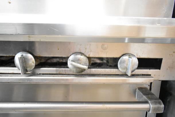 US Range Commercial Gas Charbroiler Grill with Oven, stainless steel, front view showing control knobs, visible wear.