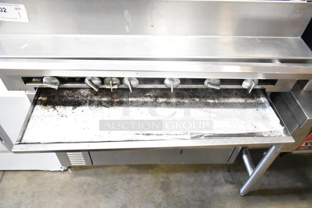 US Range commercial gas charbroiler grill with oven, featuring control knobs. Visible signs of use, stainless steel finish.