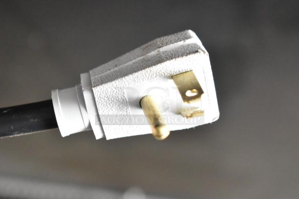 Close-up of a 115V, 1-phase plug for a 2017 True GDM-72-HC 3-door cooler merchandiser, showing slight wear.