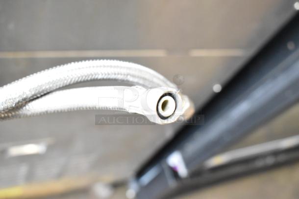 Close-up of a flexible hose connection from a 2016 Cleveland 24CGA10.2 Gemini commercial steam cabinet, showing the braided exterior.