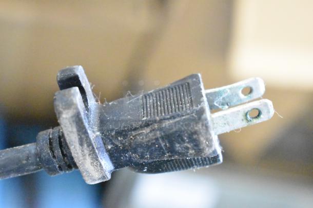 The image shows a dusty electrical plug of an Xpower P-400 Air Mover Floor Fan, suggesting prior use.