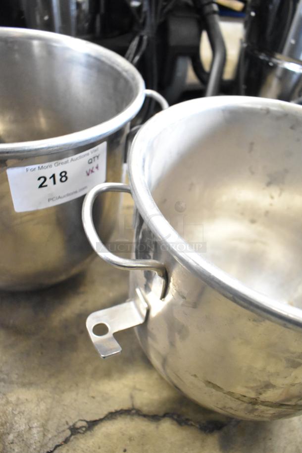 Two commercial stainless steel mixing bowls with handles and visible auction tag "218." Used condition.