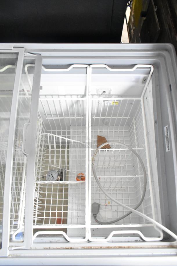 AHT RIO S 100 ice cream freezer merchandiser on casters. Features sliding glass lid and interior baskets. 115 volts, 1 phase.