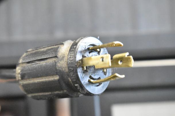 Close-up of a 3-prong electrical plug for the 2017 True GDM-72F-HC commercial freezer, showing details of its condition.