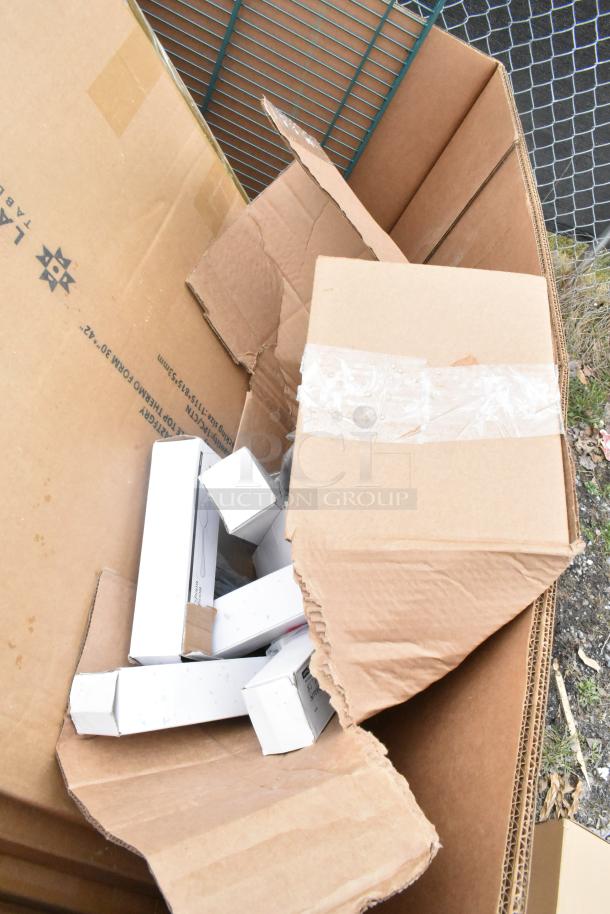 Box containing brand new scratch and dent items, including table base pieces and waitress stand, visible through open flaps.