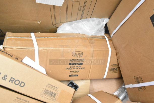 Boxes containing 17 new scratch and dent items including Lancaster table base pieces and waitress stand. Labels indicate cast iron material and item dimensions.