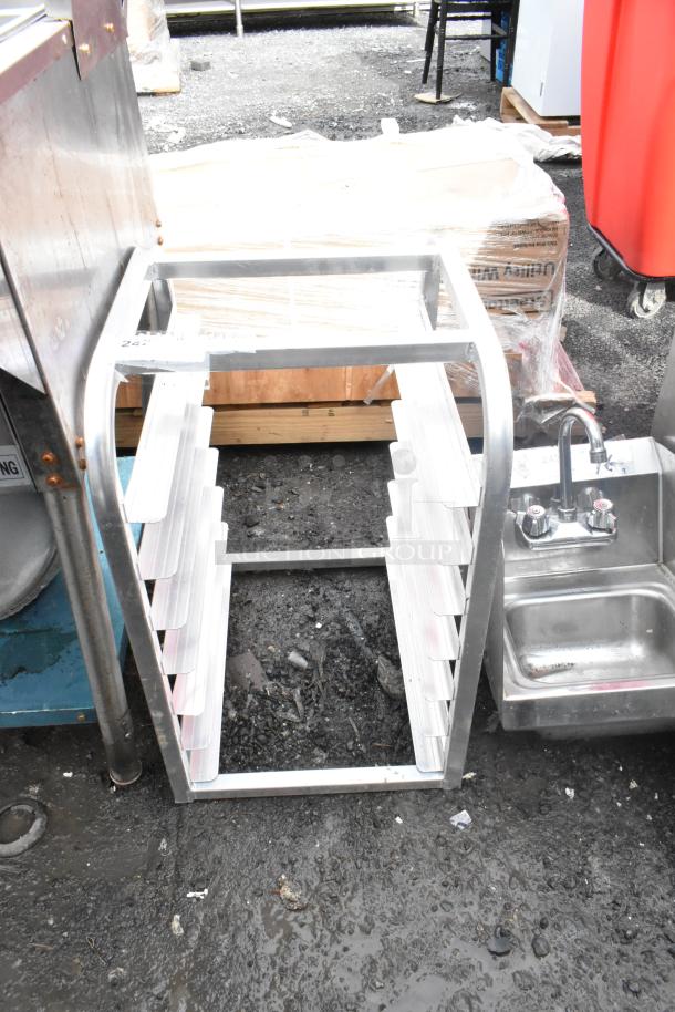 Metal commercial pan rack with multiple slots, robust construction, used condition, suitable for holding baking pans.