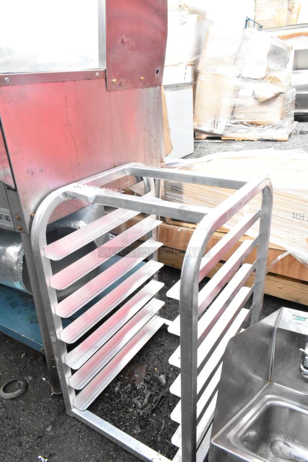 Commercial pan rack with multiple shelves, used condition, durable metal construction. Ideal for bakery or kitchen use.