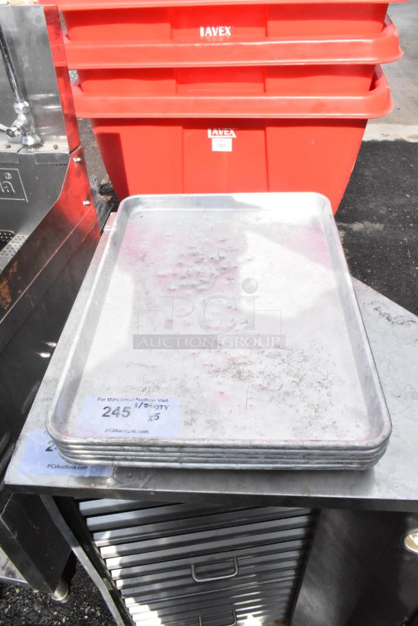 5 metal half-size baking pans, used condition, slight wear. Stack of 5. Label: "245, 5/2 QTY, x5", PCI Auctions.