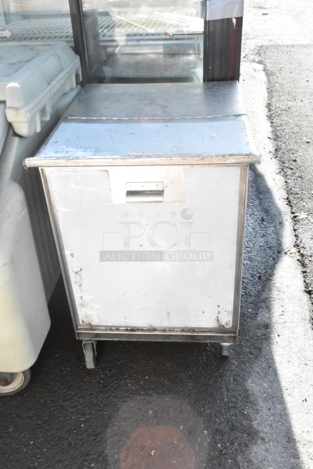 Dish cart on commercial casters, metal construction, used condition, visible wear and rust on exterior.