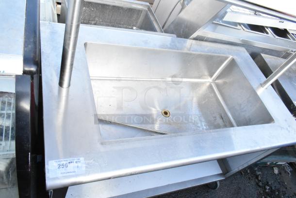 Commercial ice bin buffet station with stainless steel body on casters, drain hole, and visible label indicating auction details.