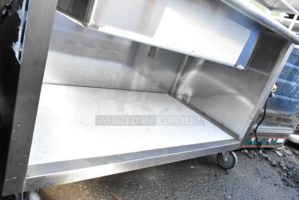 Commercial ice bin buffet station with stainless steel body, on commercial casters, showing slight wear and scratch marks.