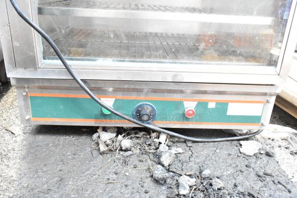 Commercial heated holding cabinet merchandiser on casters, glass doors, visible temperature controls, used condition.