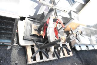 Stack of five disassembled tables with black metal bases and wood tops, placed on a pallet, showing wear.