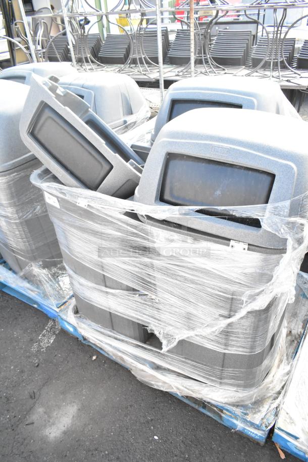 Three Toter gray poly trash can shells on a pallet, wrapped in plastic. Durable exterior, ideal for waste management.