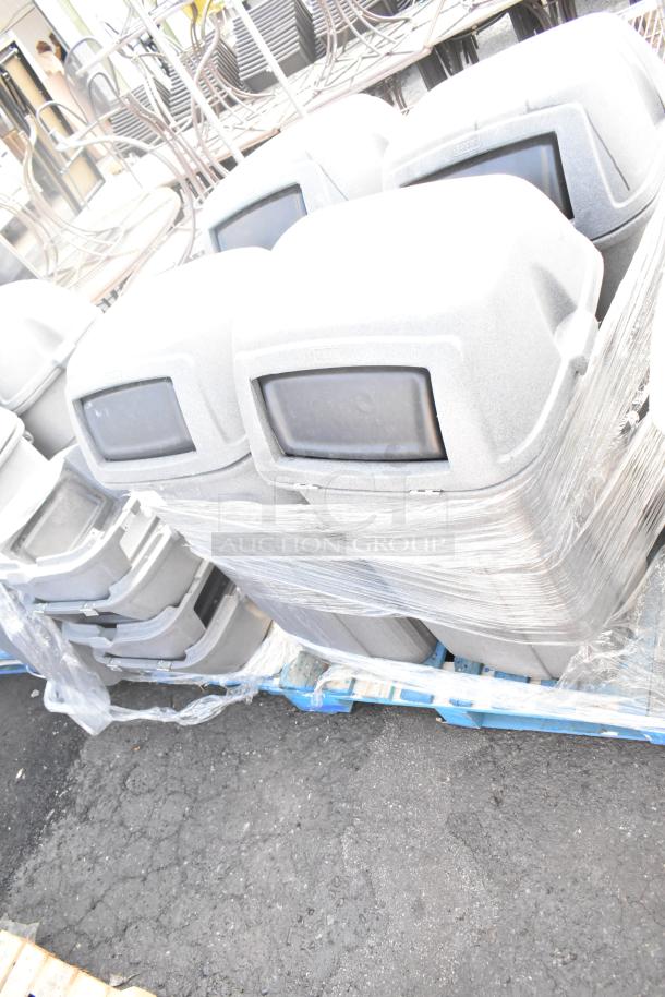 4 Toter gray poly trash can shells, secured on a pallet. Durable plastic, suitable for outdoor use. Auction includes four.