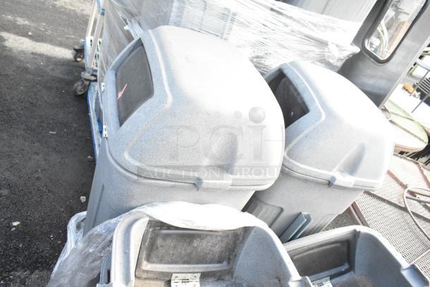 9 Toter gray poly trash can shells, weathered condition, dust-covered, includes lid, ideal for bulk waste management.