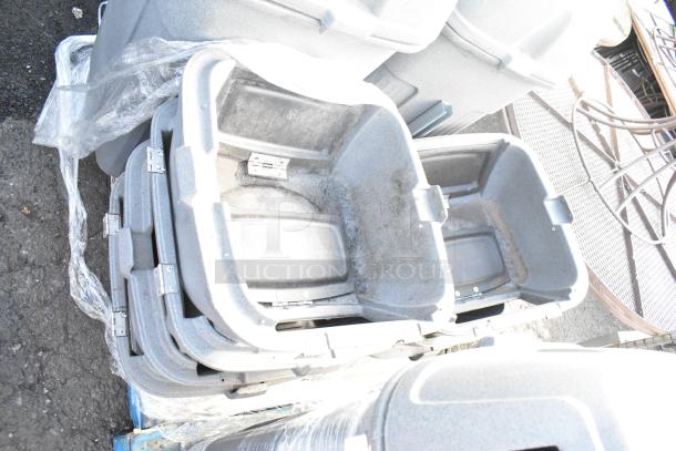 Stacked gray poly trash can shells by Toter, showing durable build and stackability, slightly scuffed condition.