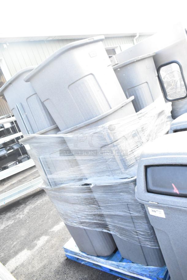 12 Toter gray poly trash can shells stacked on a pallet, wrapped in plastic. Robust, durable construction.