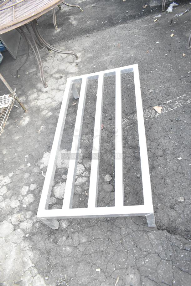 Aluminum dunnage rack with four slats, sturdy design, in good condition. Suitable for storage or commercial use.