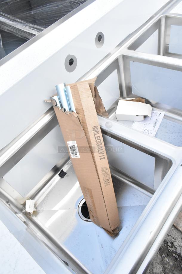 BRAND NEW Regency 600S31620218 stainless steel three-compartment sink with scratches and dents. Includes 2 drainboards, galvanized steel legs, and 16" x 20" x 12" bowls. Box labeled "600LEGGALV12."