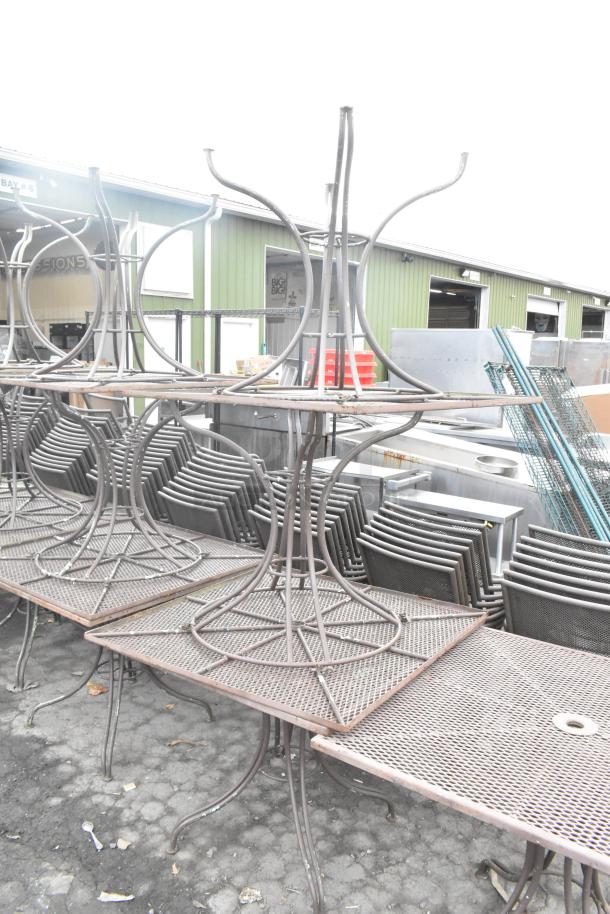 16 metal mesh patio tables, stacked outdoors, showing durable construction and weathered condition. Auction for 16 tables.