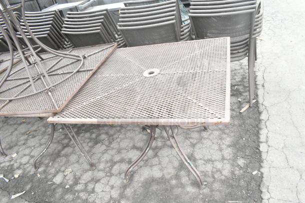 Metal mesh patio table with circular hole in center, weathered condition. Part of 16-item auction.