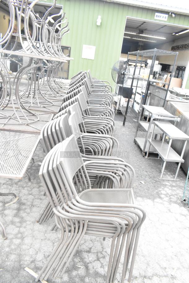 Stack of metal mesh patio arm chairs, light gray, weather-resistant, in good condition, sold in bulk of 125 units.