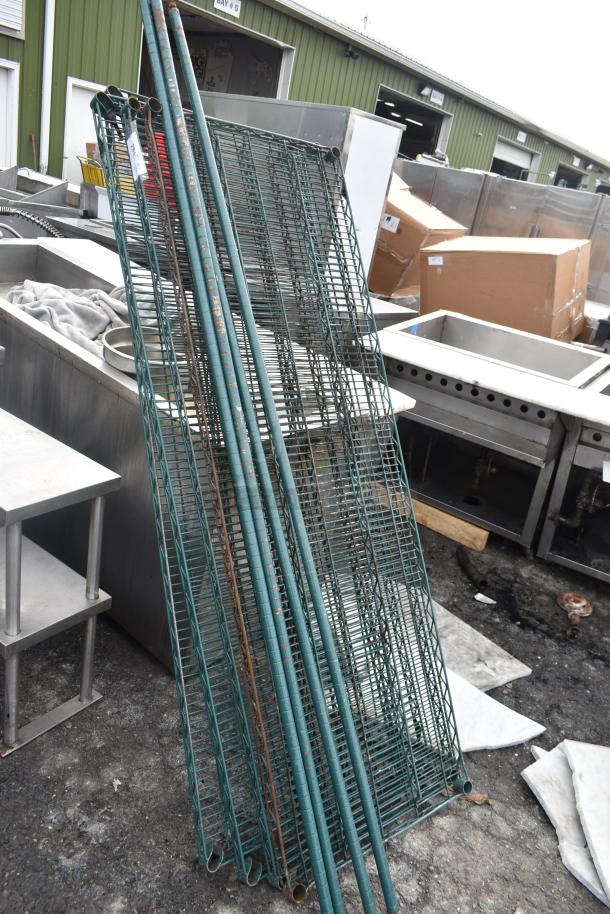 Lot of green wire shelves and poles, outdoor setting. Worn condition, ideal for storage solutions. Tags visible.