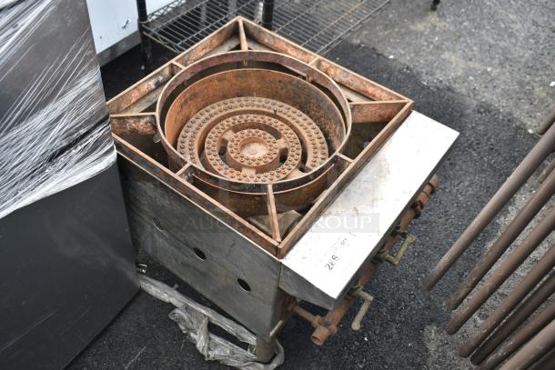 Commercial gas-powered single burner range, weathered condition, visible control valves, ideal for industrial cooking needs.