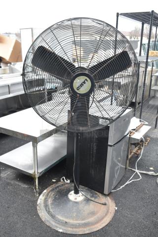 Lasko floor fan with three blades, black stand, and circular base. Label indicates 115 volts, 1 phase. Slightly worn.