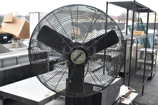 Lasko floor fan with black metal blades and grille, 115 volts, 1 phase, used condition, marked "Lasko" on center hub.