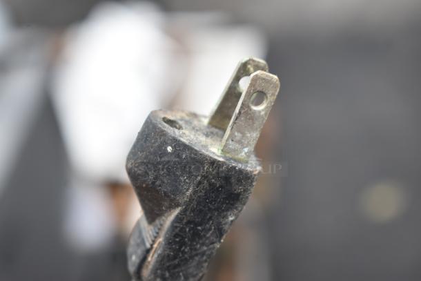 Close-up of a plug from a Lasko Floor Fan, showing slight wear. 115 Volts, 1 Phase, indicating electrical specifications.