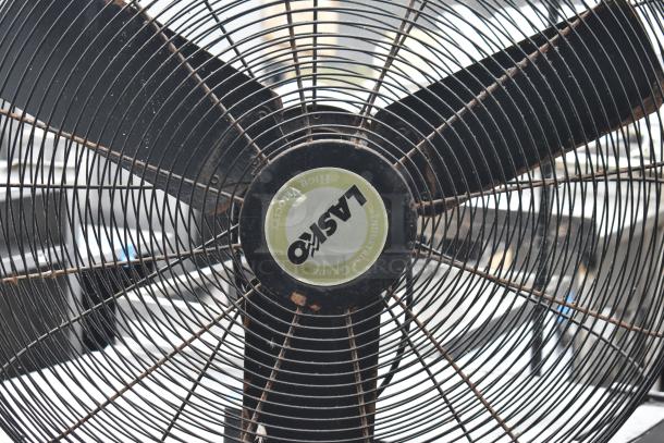 Lasko floor fan, black blades and grille, visible brand logo. 115 volts, 1 phase. Industrial grade, minor wear.