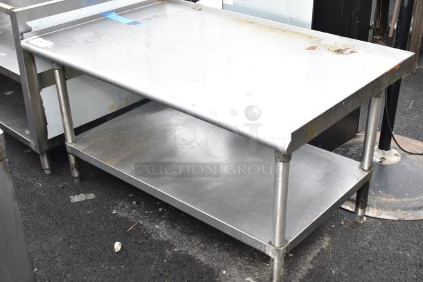 Steel commercial equipment stand with under shelf, showing signs of wear and rust; sturdy construction, suitable for kitchen use.