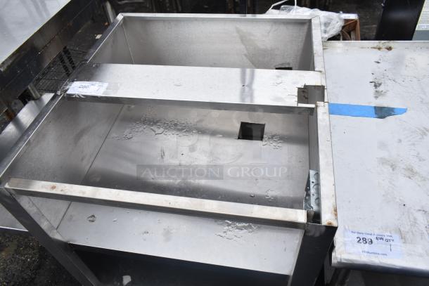 Commercial equipment stand with stainless steel construction, featuring multiple under shelves. Moderate wear visible.