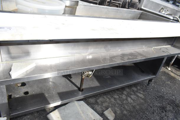 Commercial steam table, stainless steel, used condition, visible piping and shelving. May require cleaning and maintenance.