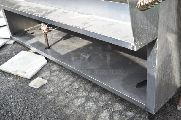 Stainless steel commercial steam table, showing lower storage area and pipe fittings, in used condition.