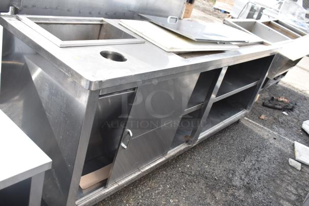 Commercial stainless steel prep station with under shelves, used condition, includes sink and sliding door cabinet.