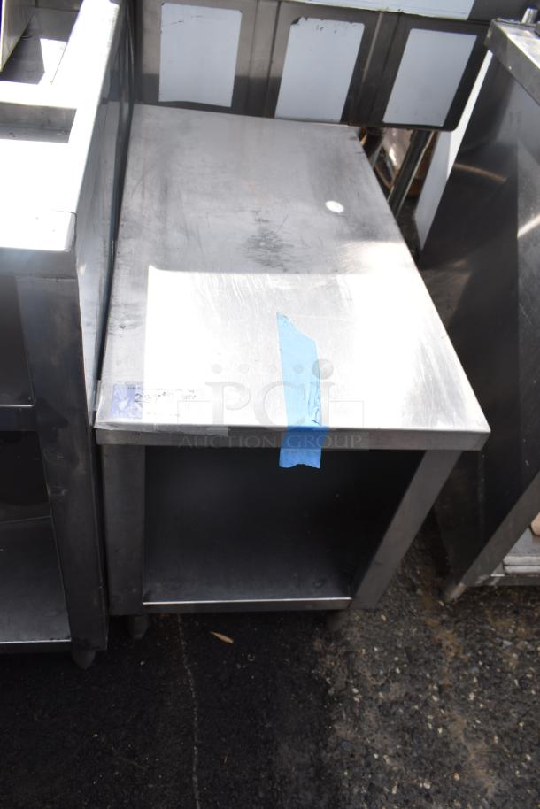 Commercial equipment stand with under shelf, stainless steel, used condition, visible blue tape marking on top.