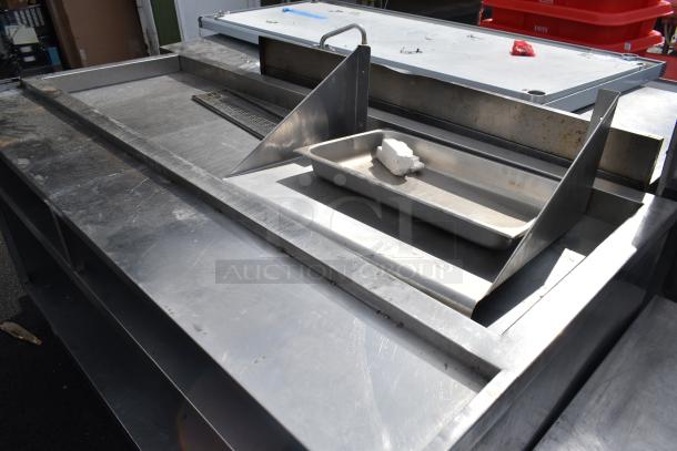 Commercial soda station with under shelf, stainless steel, slight wear, includes drainage area and splash guard.
