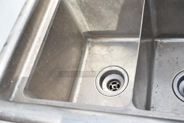 Commercial 3 bay sink, stainless steel, visible wear, twin drains. Ideal for restaurant use.