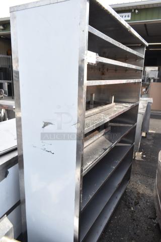 Commercial shelving unit, metal frame with five shelves, moderate wear, scuffs on the side; suitable for industrial use.