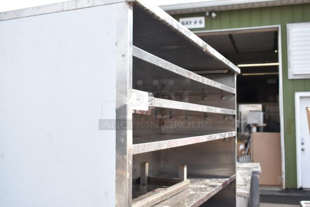 Commercial shelving unit, metal construction, multiple horizontal shelves, slight wear, white label with "303" marking.