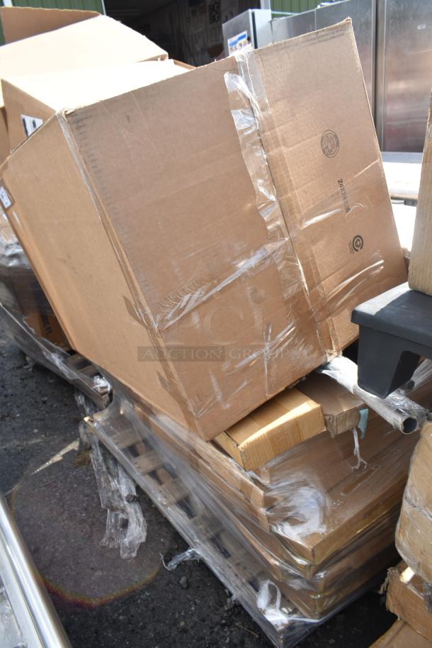 15 brand new scratch and dent items in cardboard boxes, including table base pieces, sealed on a pallet.