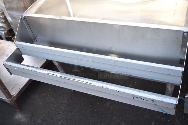 Commercial ice bin with double speed well, stainless steel, visible wear. Ideal for bar use, sturdy and spacious design.