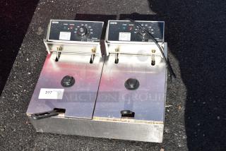Countertop electric 2-bay fryer with 2 metal baskets, lids, 110V, 1-phase, good condition, visible control panel and power cord.