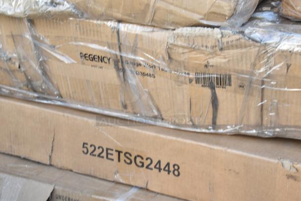 Cardboard boxes with "Regency 16 Gauge Work Table" marking, wrapped in plastic, labeled "522ETSG2448," scratch and dent condition.