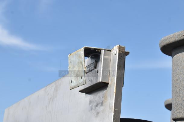 Eliason stainless steel swinging kitchen door with visible hardware and markings. Good condition.